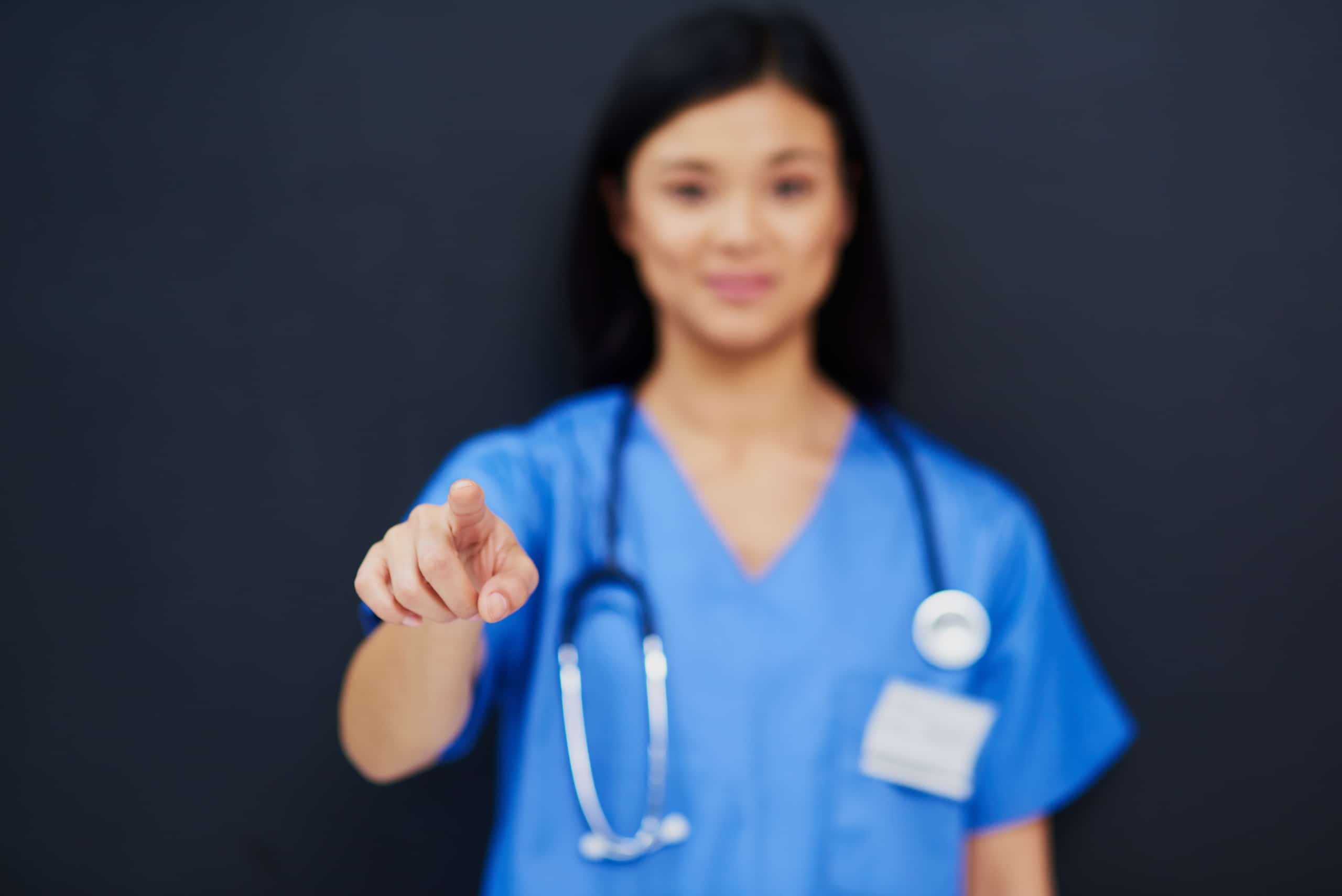 Blurred nurse pointing a finger toward the camera