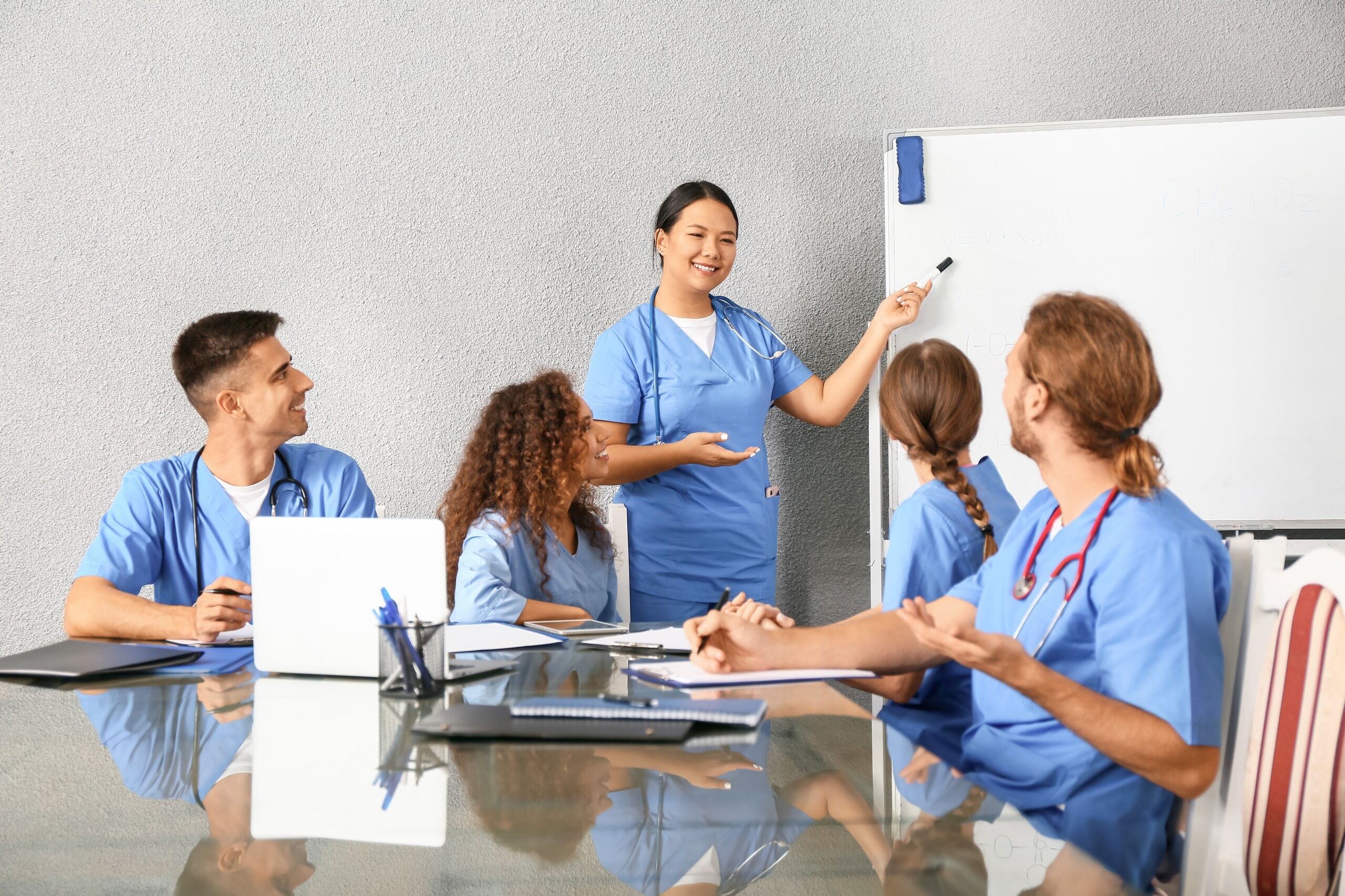 Group of medical students in a conference room using a whiteboard