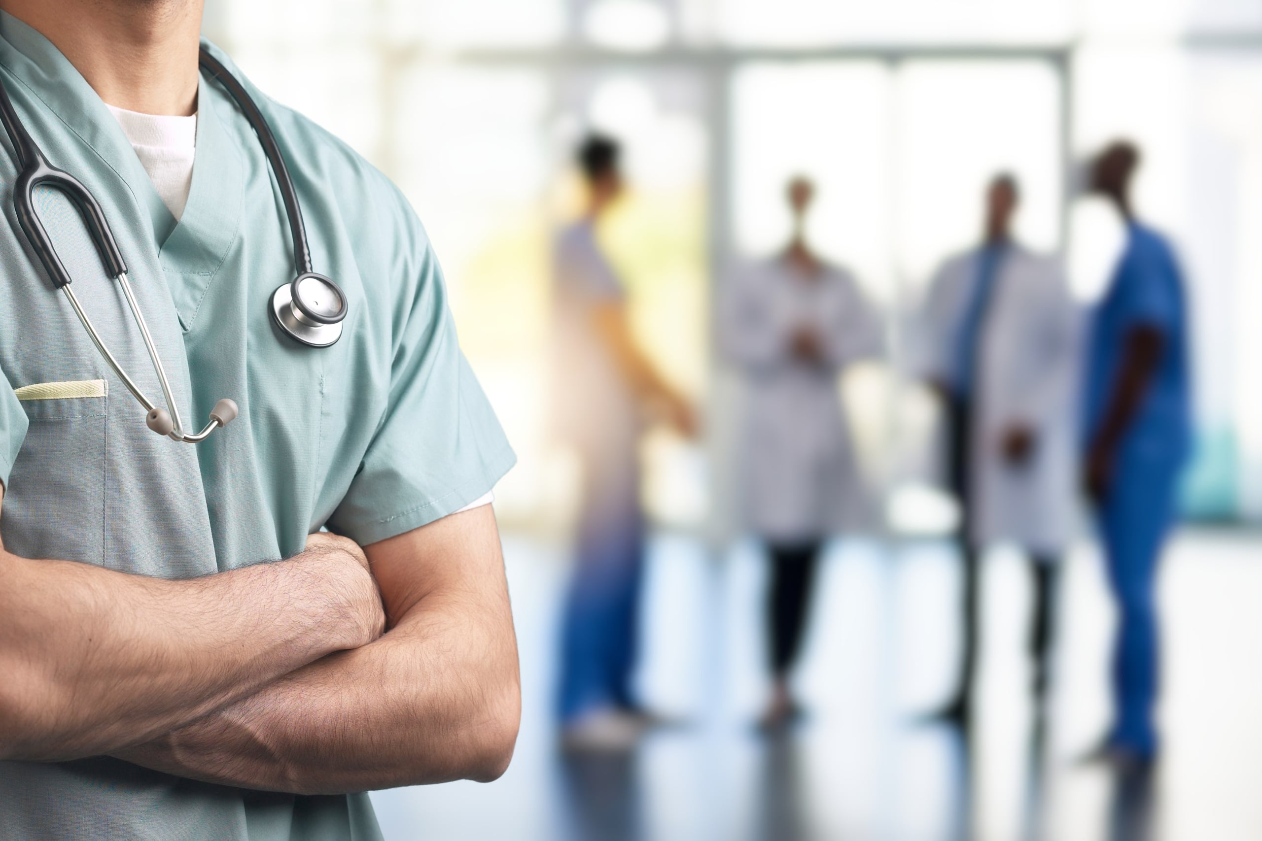 Close up of a medical professional in scrubs standing inside a hospital