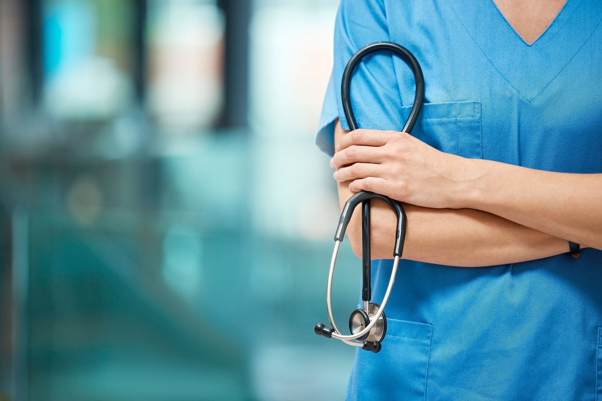 Close up of a nurse in scrubs holding a stethoscope